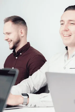 vorza360 team members smiling while working on laptops